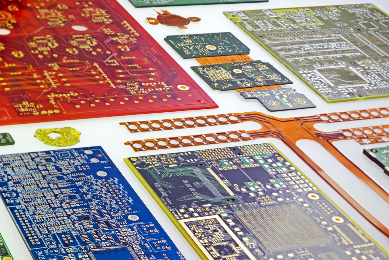 Vielfältiges Portfolio an CONTAG Leiterplatten: Auswahl verschiedener Technologien wie Starr-Flex-Schaltungen, farbige Multilayer in Rot und Blau sowie hochkomplexe HDI-Leiterplatten auf hellem Untergrund.