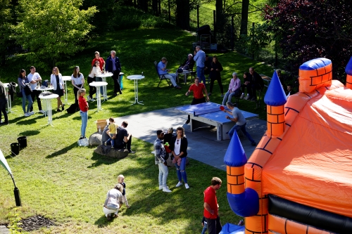 Familienfreundlichkeit bei CONTAG: Mitarbeiter der CONTAG AG beim entspannten Sommerfest im Grünen mit Tischtennisplatte, Stehtischen und einer Hüpfburg.